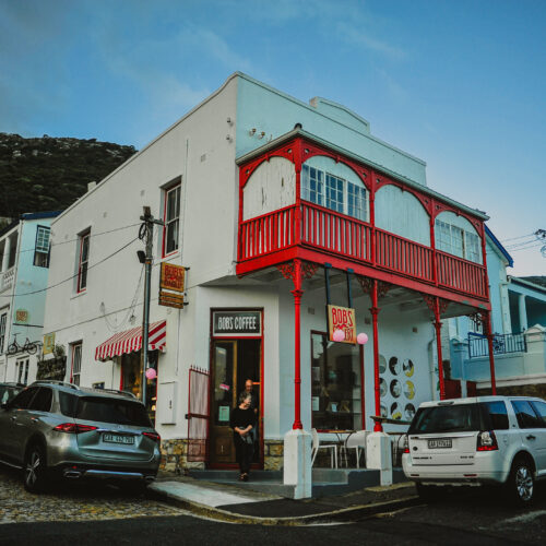 Person of Colour standing in front of a blue wall